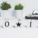 Minimalist desk setup with motivational blocks spelling 'Do It' and small potted plants.